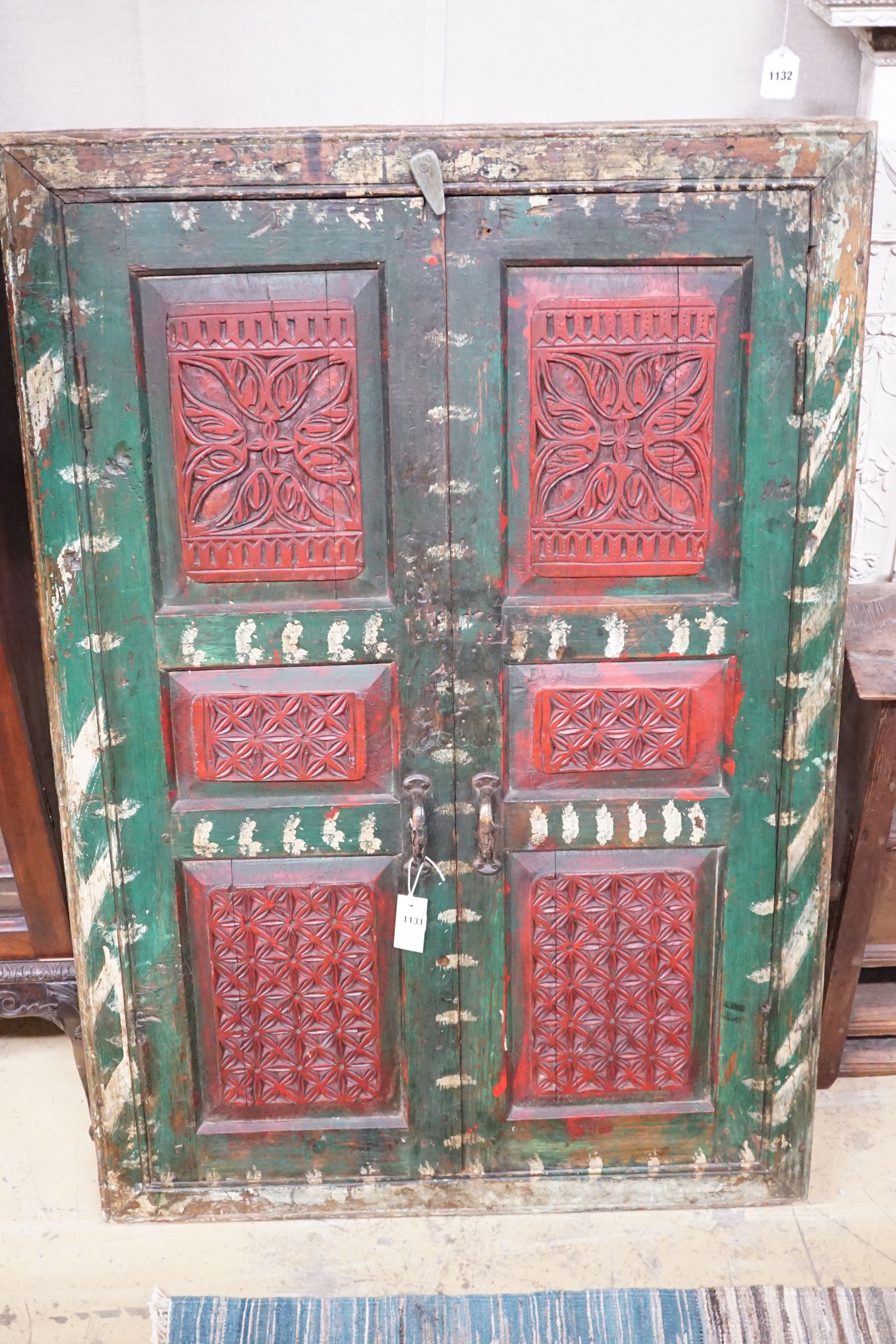 An Indian painted carved hardwood corner cupboard, width 90cm, height 131cm